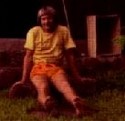 Ron Marlett sitting in front of his Tahitian hut.